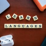 Flat lay of language learning materials with gadgets promoting education.