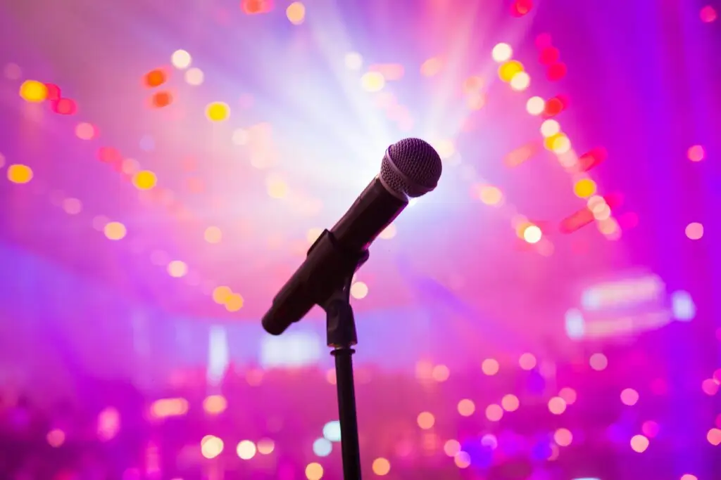 Close-up of a microphone against colorful bokeh lights, perfect for music or entertainment themes.