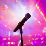 Close-up of a microphone against colorful bokeh lights, perfect for music or entertainment themes.